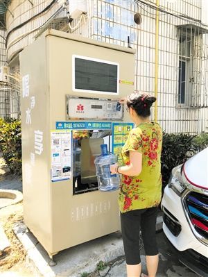 5月24日，瓊山區(qū)上丹花苑小區(qū)居民陳女士在使用共享凈水機取水。 本報記者 陳歆卓 攝